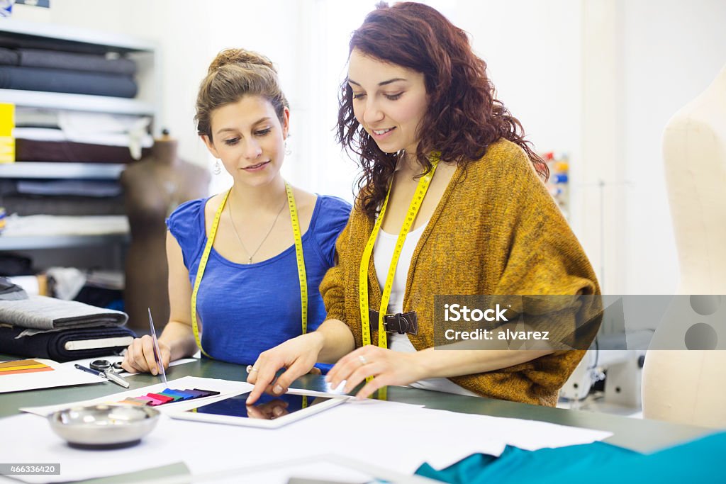 Young women checking some fashion ideas on digital tablet Young female fashion designers checking some fashion ideas on digital tablet in design studio 20-29 Years Stock Photo