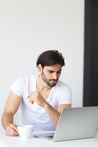 jovem homem a trabalhar a partir de casa - using laptop contemplation accessibility contemporary imagens e fotografias de stock