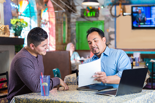 Restaurant manager reading employee resume during interview