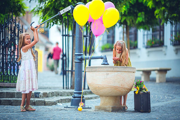 Two pretty young girls are enjoying being together outside on the street.