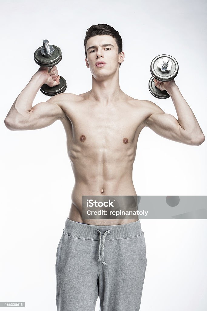 Hombre sin camisa joven sosteniendo Mancuernas - Foto de stock de 20 a 29 años libre de derechos