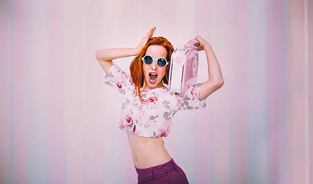 Photo of Woman Wearing Sunglasses dances With Vintage Radio