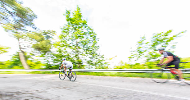 dois ciclistas em countryroad - racing bicycle cyclist sports race panning imagens e fotografias de stock