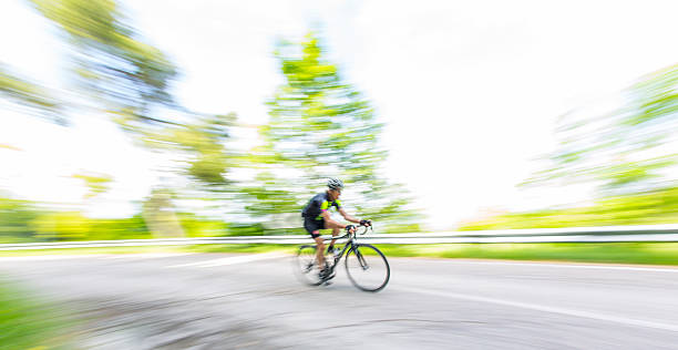 ciclista em countryroad - racing bicycle cyclist sports race panning imagens e fotografias de stock
