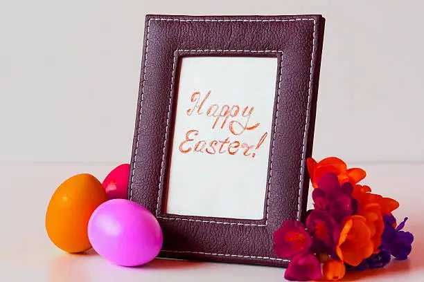 Photo of Easter eggs and freesia in basket on white background