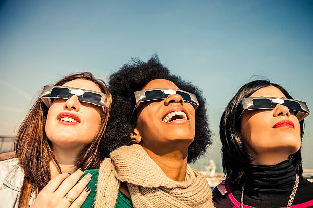istock Group of friends looking to a solar eclipse 466341184