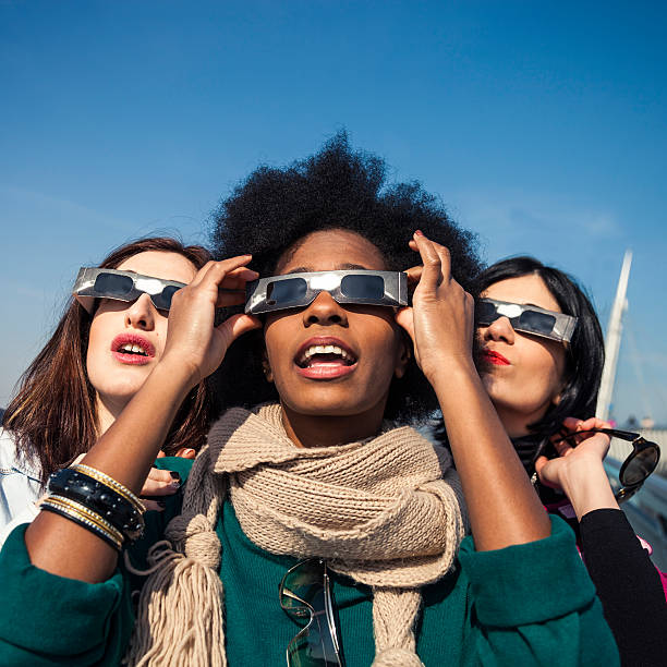 istock Group of friends looking to a solar eclipse 466341192