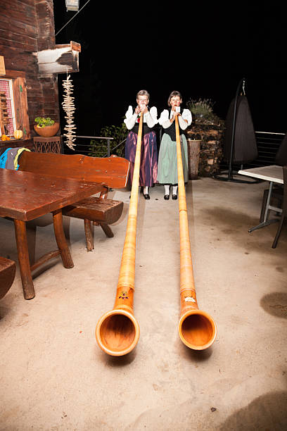 typical Swiss ladies play  Alpenhorn outside cafe typical Swiss ladies play  Alpenhorn outside cafe alpenhorn stock pictures, royalty-free photos & images