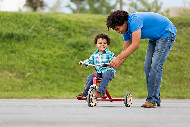 istock Smiling father assisting son in tricycle 466341630