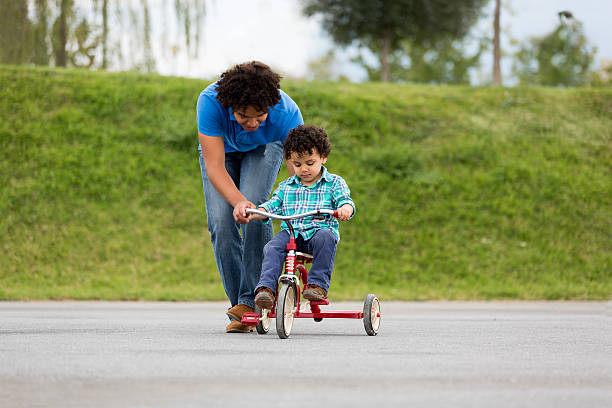 Happy father assisting son in tricycle