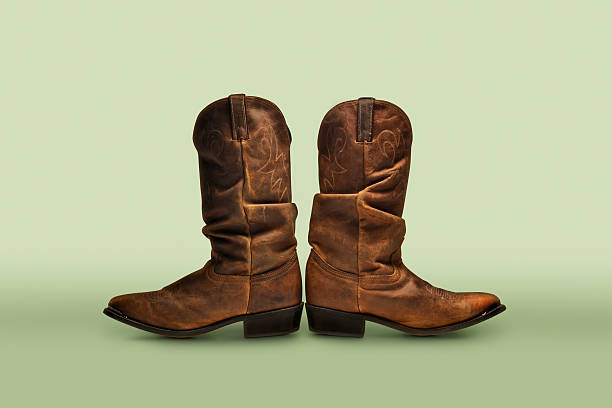istock Two cowboy boots facing in opposite direction on green background 466341658