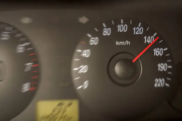 tachometer in a driving car with 145 km/h with motion blur