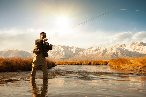 A silhouette of a fisherman casting his rod in the river.  http://blog.michaelsvoboda.com/FishingBanner.jpg
