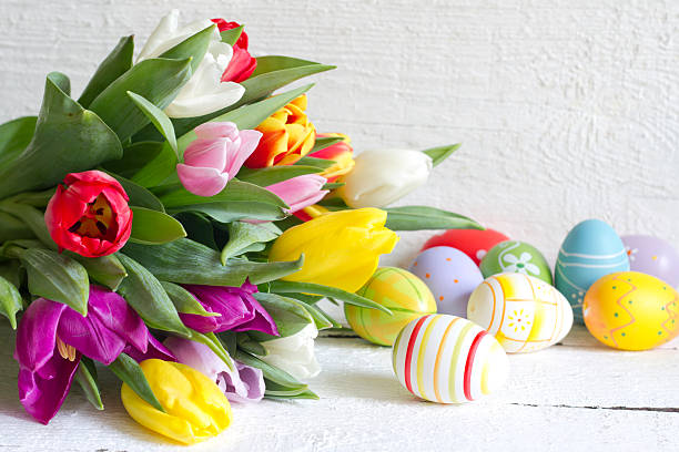 istock Easter eggs and tulips on wooden board 466346898
