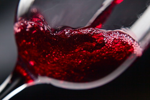 Red wine in wineglass on  black background