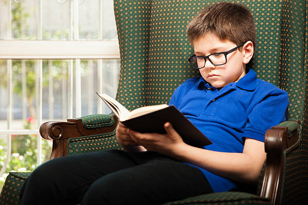 istock Little blond boy reading at home 466353866