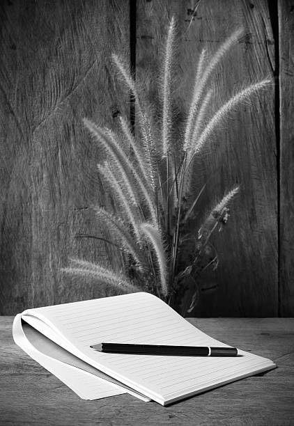 istock Black and white  notebooks with  foxtail weed  on wooden board 466359649