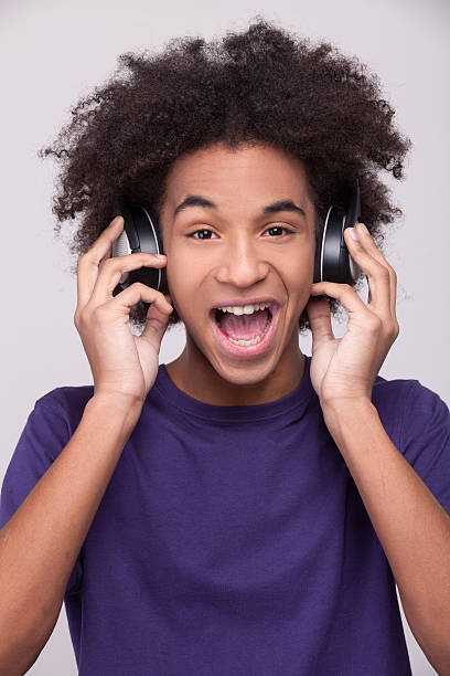 sulking cute teenager boy with hair over his eyes and headphones.