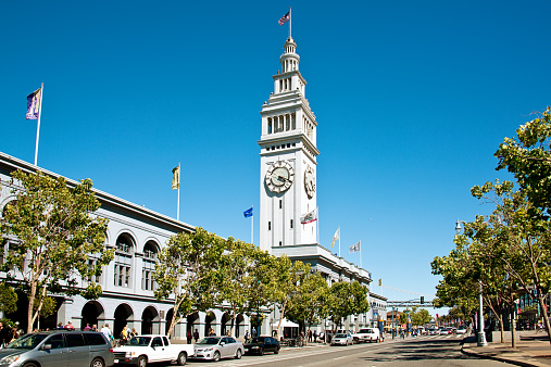 San Francisco, USA - June 27, 2013: Ferry Building at the Embarcadero, in downtown San Francisco, California. The Embarcadero is the eastern waterfront and roadway of the Port of San Francisco,constructed atop an engineered seawall on reclaimed land. People walking.