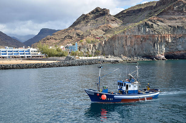 Fishing boat enters the harbor, Puerto de Mogan, Gran Canaria stock photo
