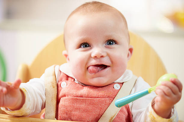 Portrait Of Happy Young Baby Boy In High Chair Portrait Of Happy Young Baby Boy In High Chair Waiting For Food 8 weeks stock pictures, royalty-free photos & images