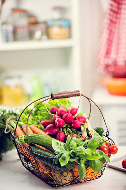 Basket with organic vegetables like cucmbers, tomatoes, radishes, paprika, salad, poatatoes, basil and other herbs. All choosen fresh from market.