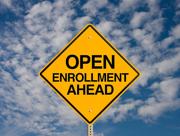 istock Road sign against sky background stating open enrollment 466377068