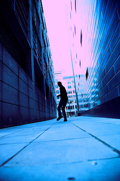 A man running in between two buildings stock photo