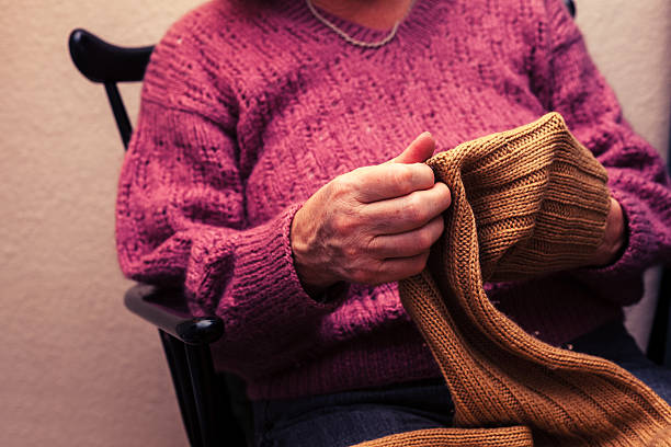 istock Old woman mending a jumper at home 466381455