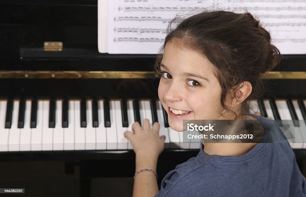 Piano lesson Young girl seated in front of a piano keyboard Piano Stock Photo