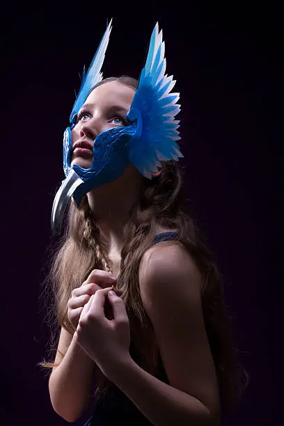 Beautiful young blonde girl with blue valkyrie mask wit wings