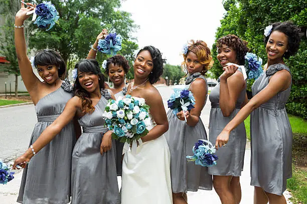 Bridesmaids helping the bride get dressed.