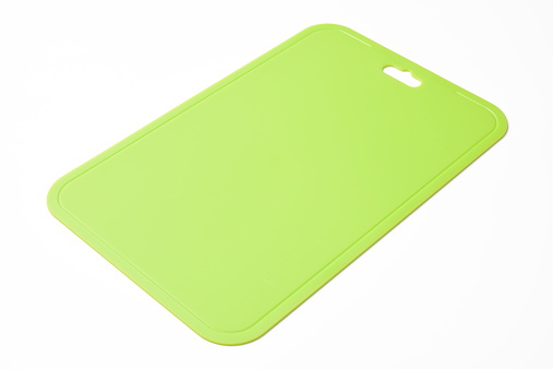 High angle view of green plastic cutting board, isolated on white background with clipping path.