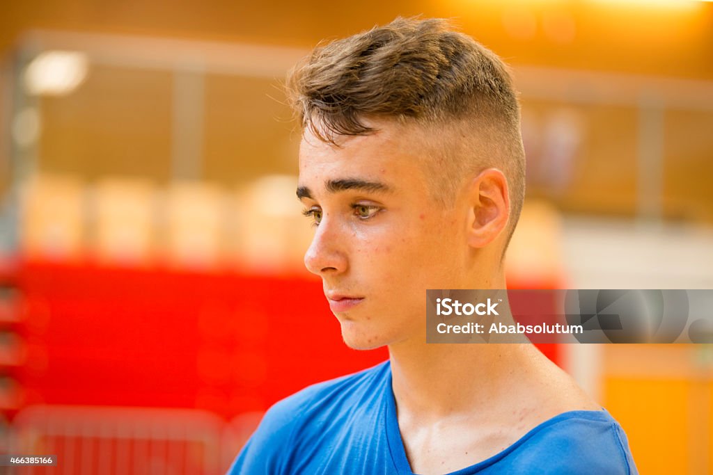 Portrait of Pensive Teenager after Playing Basketball, School Gymnasium, Europe Portrait of an exhausted teenager soon after training/playing/competition/losing in the school gymnasium, Europe. Nikon D800, full frame, XXXL. 14-15 Years Stock Photo