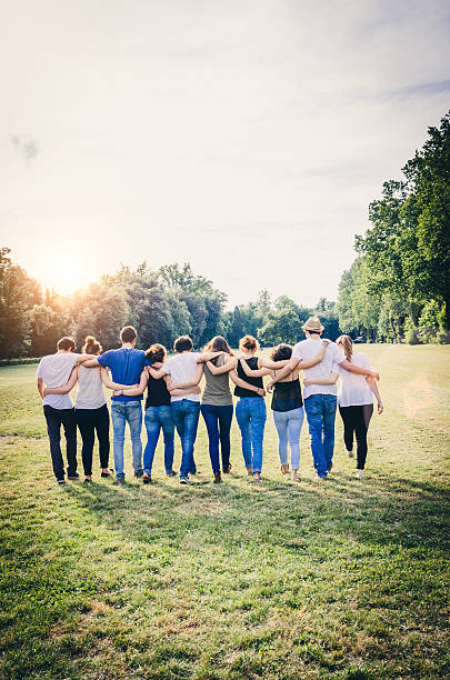 Group Of Friends Walking Together Group Of Friends Walking Together arm in arm stock pictures, royalty-free photos & images