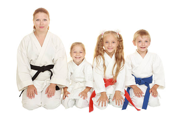 istock Mother with daughter, boy with sister sitting in karate pose 466386569