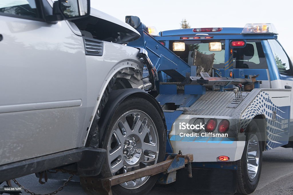 Tow Truck Wreck A damaged new vehicle on a tow truck. Medium shot. Towing Stock Photo