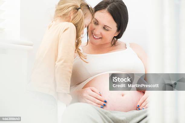 Mother And Daughter Have Fun Together Looking At Baby Bump Stock Photo - Download Image Now