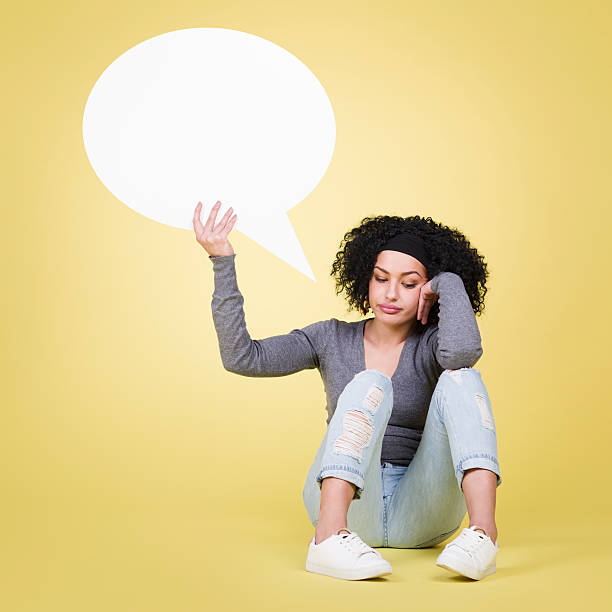 istock Unhappy girl holding a white speech balloon with copyspace. 466388722