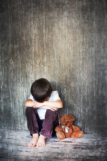 istock Young boy, sitting on the floor with teddy bear 466391250