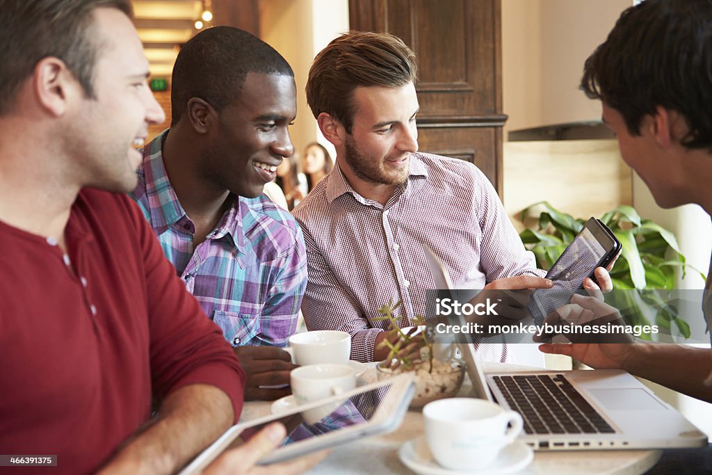 Group Of Male Friends Meeting In Café Restaurant Group Of Male Friends Meeting In Café Restaurant Using Digital Tablet 20-29 Years Stock Photo