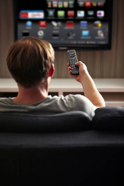 Man watching TV Man watching TV smart tv stock pictures, royalty-free photos & images