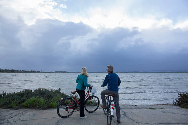 istock Biking couple pause by water edge, look out 466391914
