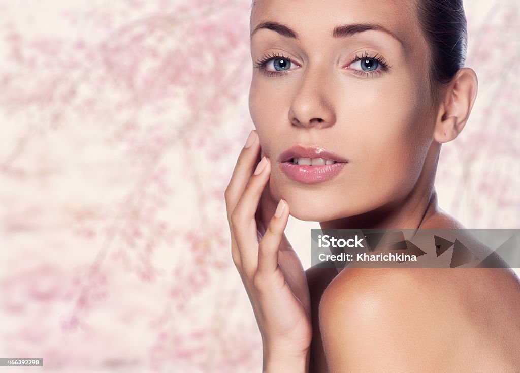 Beautiful face of young adult woman with clean fresh skin Beautiful Young Woman Touching Her Face.Fresh Healthy Skin.Isolated on White 2015 Stock Photo