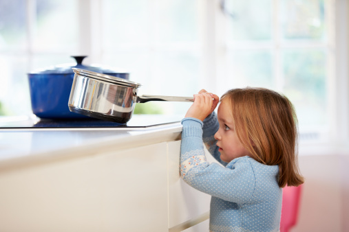 Young Girl Risking Accident With Pan In Brightly Lit Kitchen