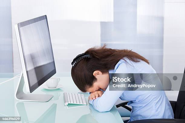 Tired Businesswoman Leaning At Office Desk Stock Photo - Download Image Now - 'at' Symbol, Adult, Adults Only