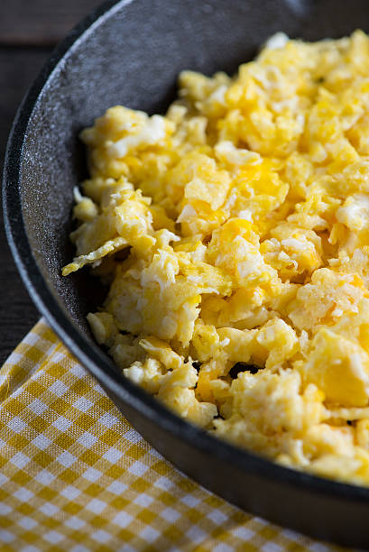istock scrambled eggs in vintage frying iron pan, overhead view 466406264