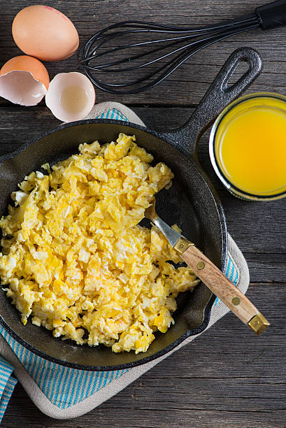 istock scrambled eggs in vintage frying iron pan, overhead view 466406276