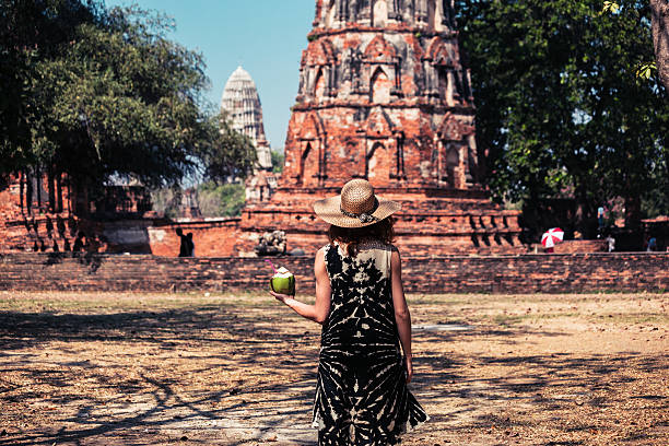 istock Woman drinking coconut juice by ancient temple 466406768