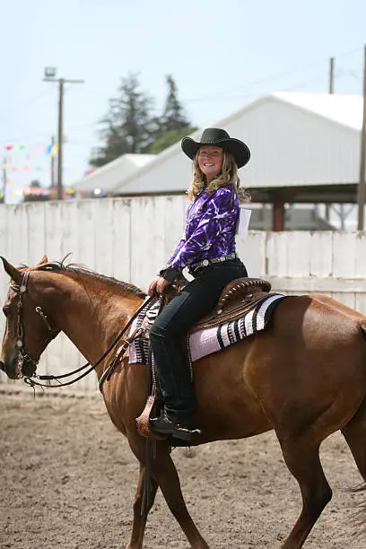 cowgirl contestant riding her horse in an arena during fair